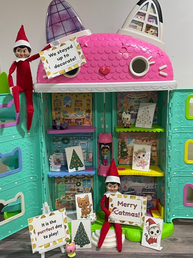 Gabby Dollhouse Inspired Elf on the Shelf Idea that includes printable dollhouse backgrounds, cat Christmas decor, and elf cutouts.